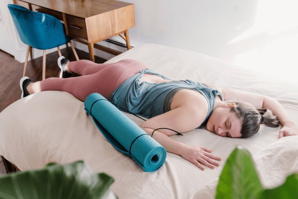 sport kifogások - nő fáradtan az ágyra dőlt edzés után