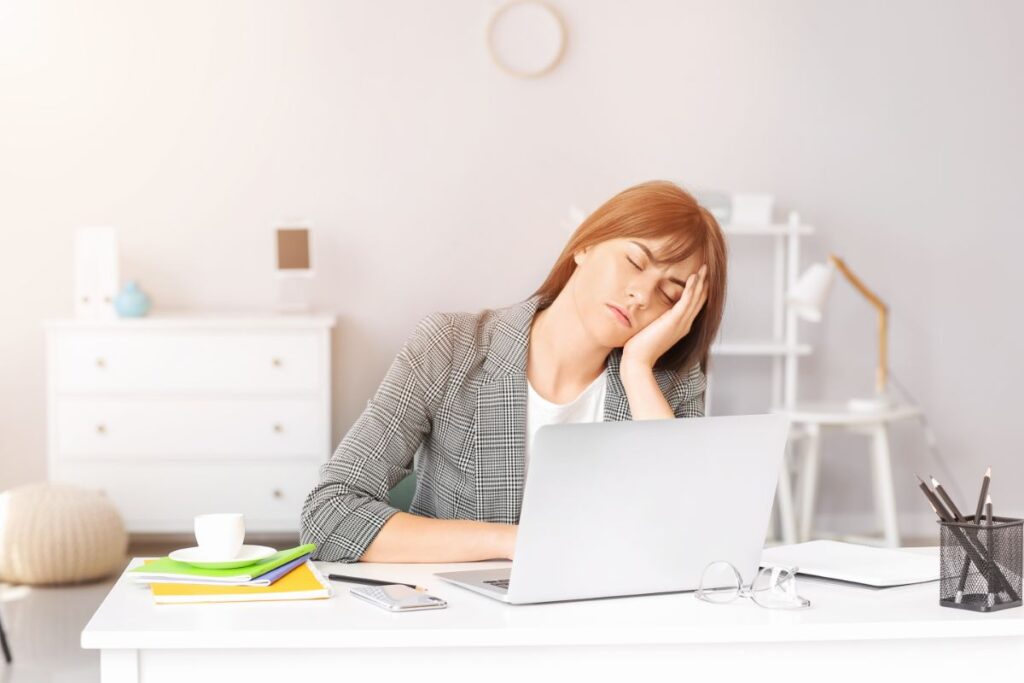 alváshalogatás - nő elalszik a munkahelyen